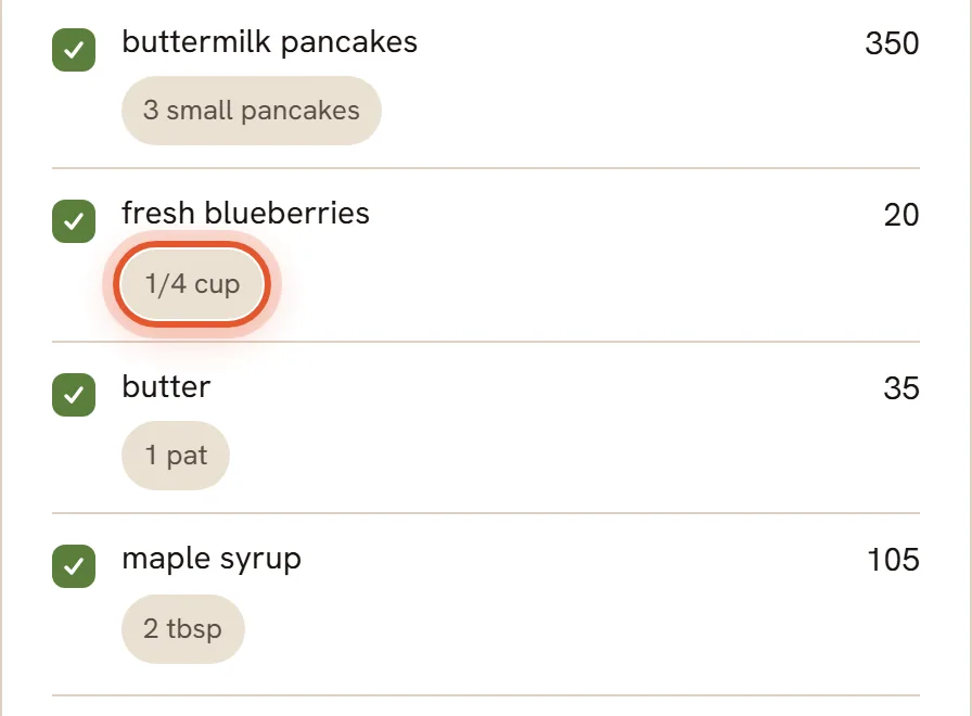 The list of foods found: buttermilk pancakes, fresh blueberries and butter, each with a tick box and a portion. The 1/4 cup portion of the blueberries is ringed.
